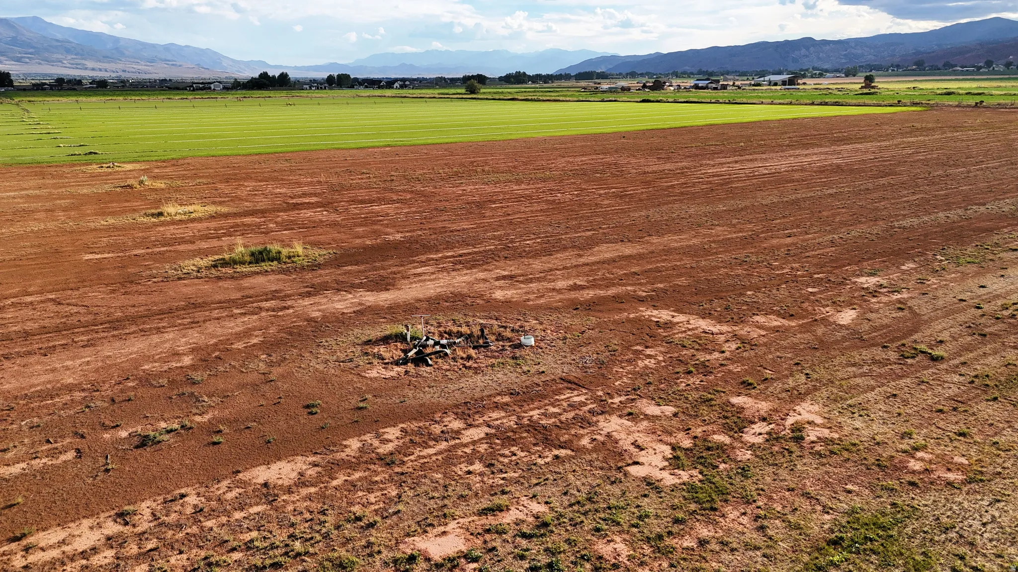 Expansive land parcel featuring cultivated fields and distant mountain ranges