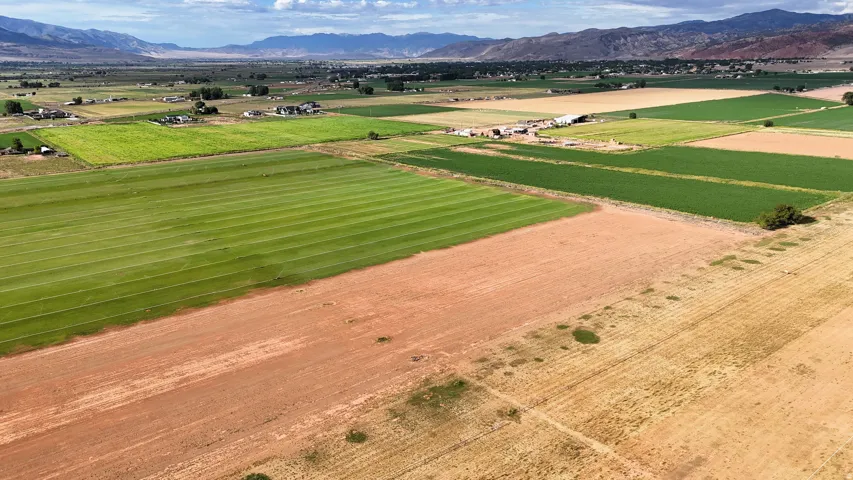 Expansive agricultural acreage featuring cultivated fields, open land, and distant mountain ranges