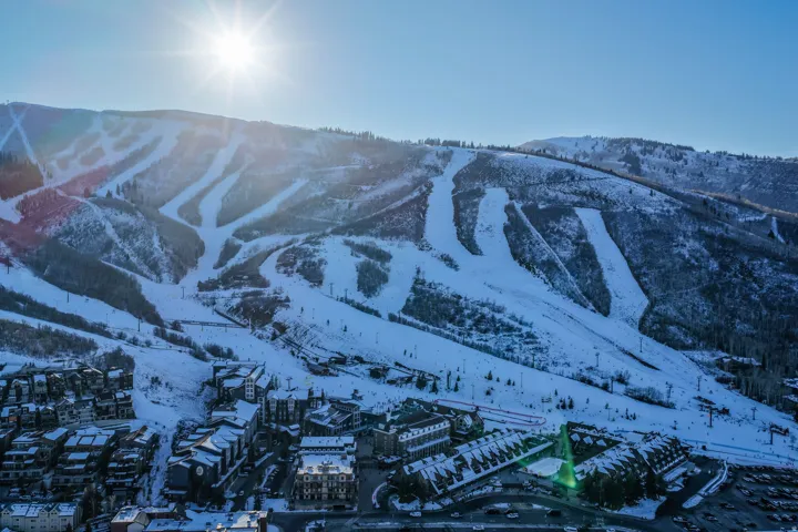 Mountain resort community featuring ski slopes, residential structures, and parking areas