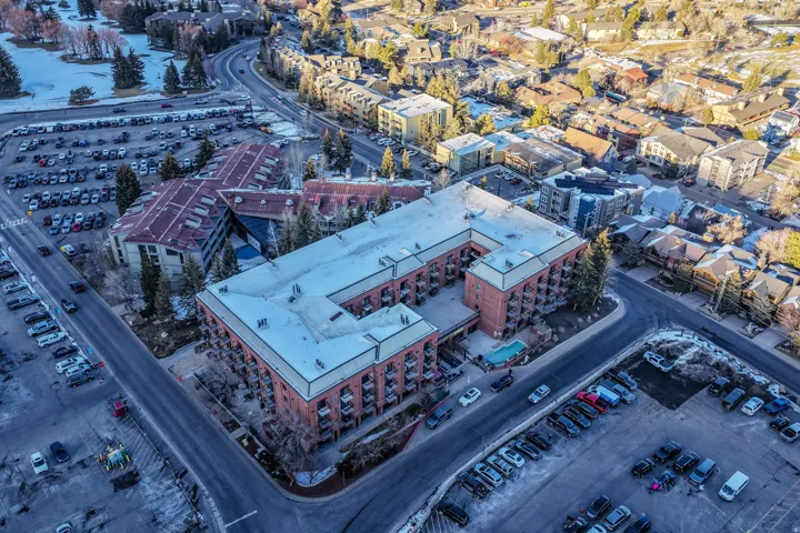 Multi-story brick facade building featuring exterior balconies and a central courtyard pool