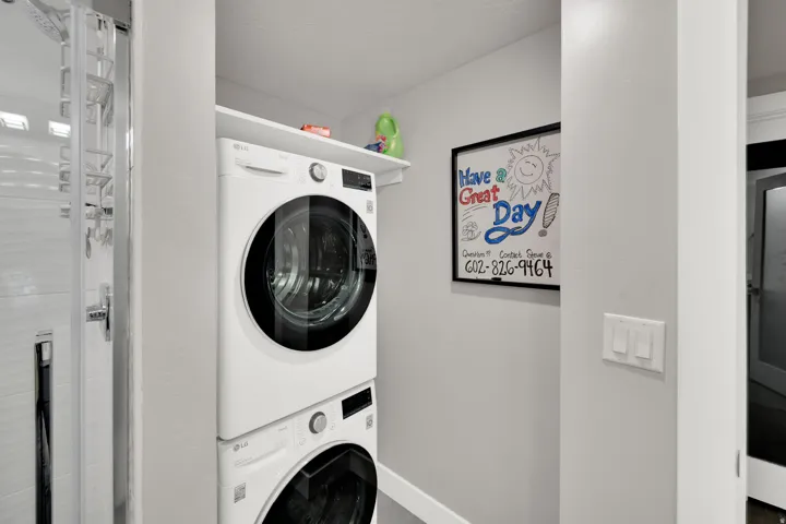 Stacked washer and dryer unit with an adjacent shower enclosure