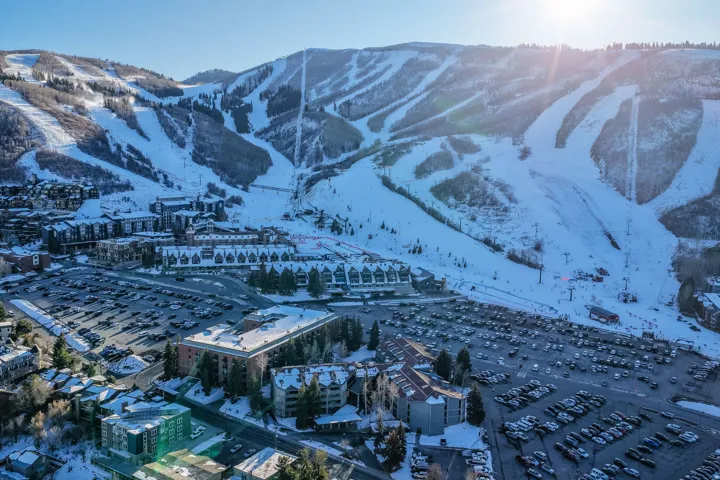 Snow-covered mountain terrain, multiple ski slopes, and ski lifts