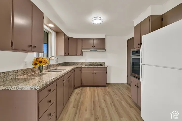 Kitchen featuring New LVP wood-finish flooring, light-toned countertops, and ample cabinetry