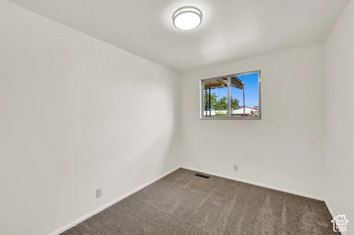 Recessed window with aluminum frame, New neutral carpeting, and overhead flush-mount lighting