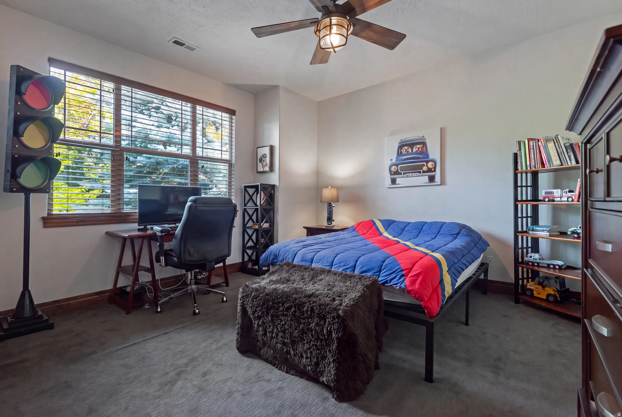 Generously sized window with wood-finish blinds, wood-finish flooring, ceiling fan with integrated lighting, and built-in shelving unit