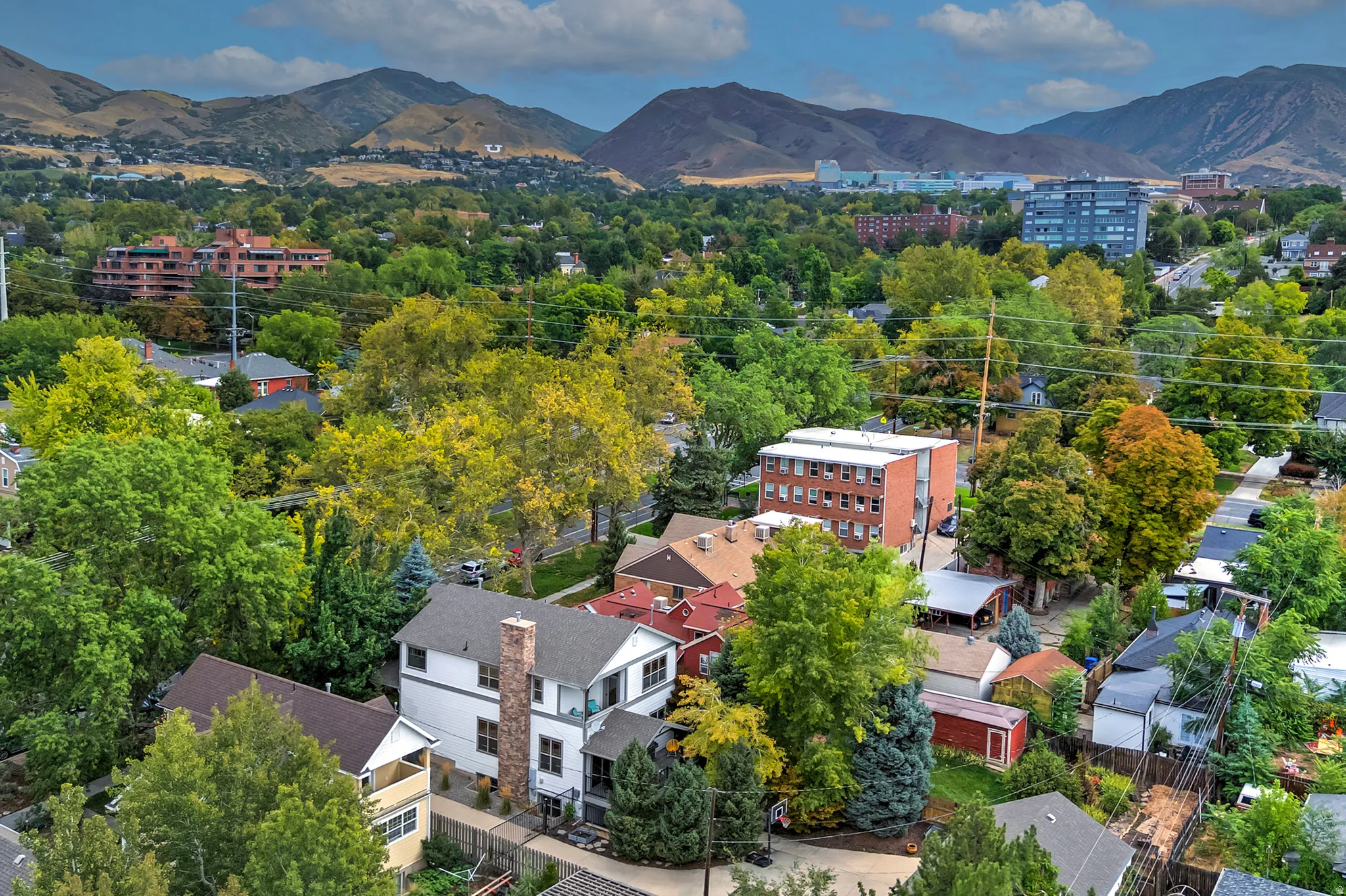 Neighborhood setting with mature trees and distant mountain backdrop
