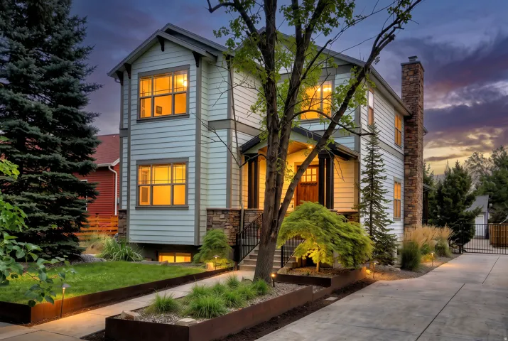 Multi-level facade with light-colored siding and stone accents