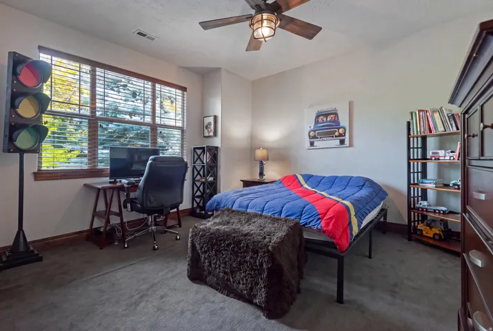 Generously sized window with wood-finish blinds, wood-finish flooring, ceiling fan with integrated lighting, and built-in shelving unit