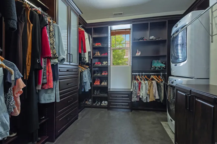 Custom closet system featuring dark wood-finish cabinetry, integrated shelving, and multiple storage drawers