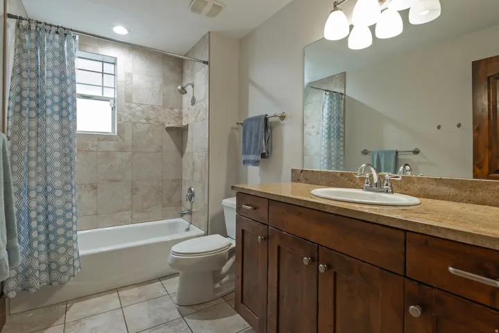 Built-in vanity with wood-finish cabinetry, a single basin sink, and a light-toned countertop