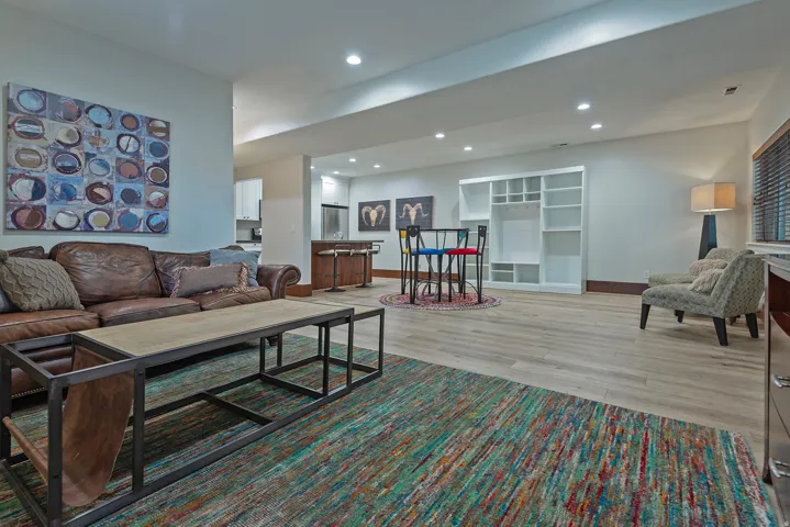 Recessed lighting, light wood-finish flooring, built-in shelving, and a bar area with built-in cabinetry