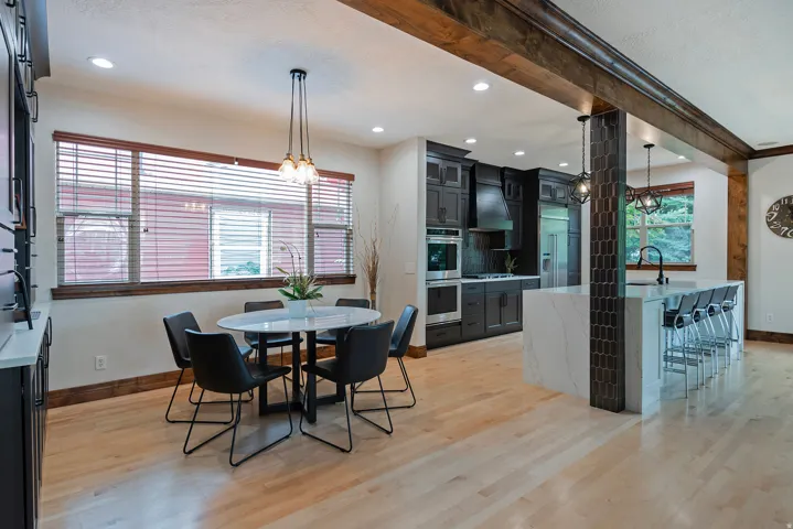 Light wood-finish flooring complements the modern dark cabinetry and stainless steel appliances