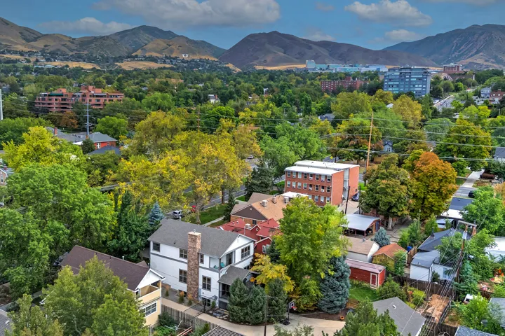 Neighborhood setting with mature trees and distant mountain backdrop