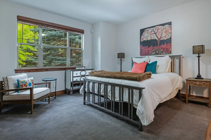 Expansive window with wood trim, gray carpet flooring, and white walls