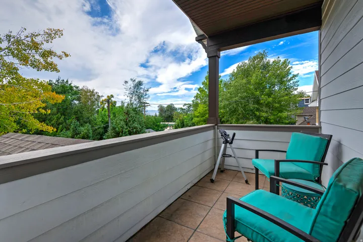 Covered balcony featuring siding walls, a tiled floor, and a dark-stained wood ceiling