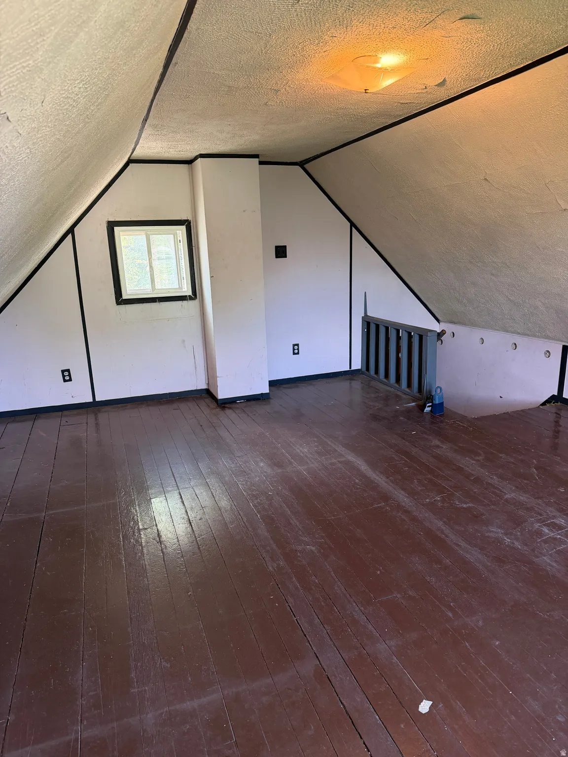 Attic, Wood-plank flooring, vaulted ceilings, and an exposed ceiling light fixture