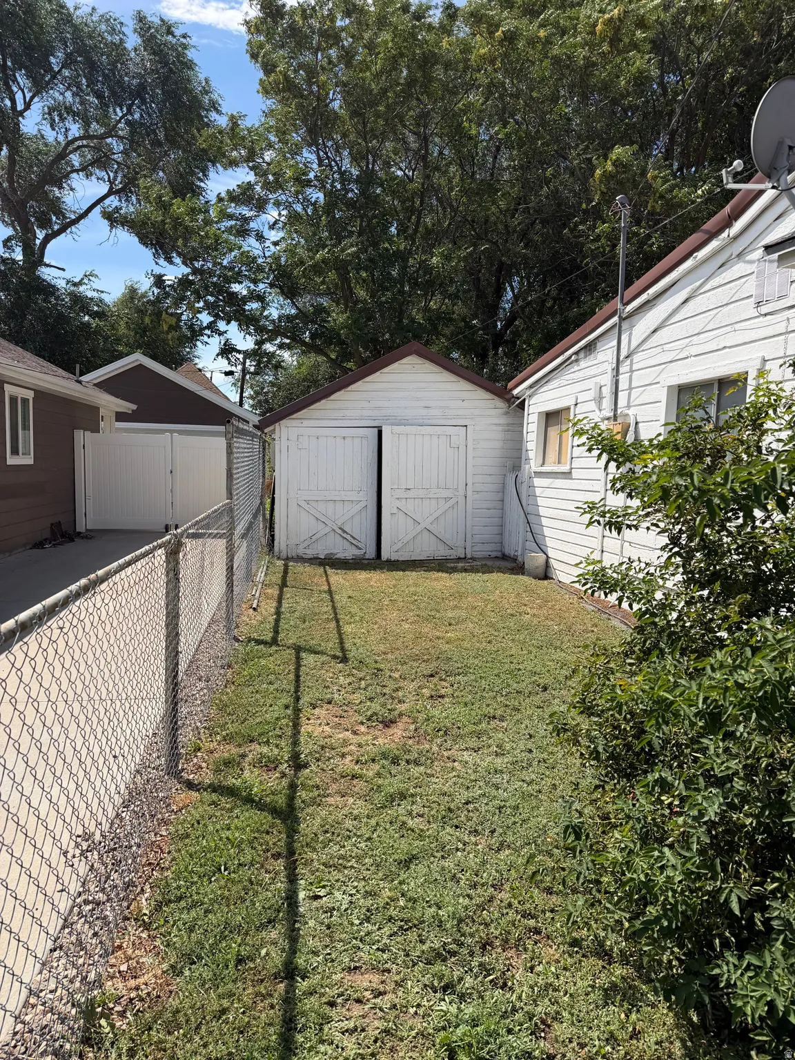 Detached white garage with barn-style doors