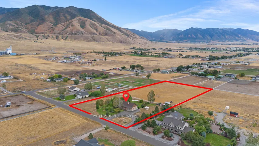 Mountain backdrop, expansive lot, established landscaping, paved road access, residential setting