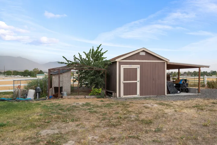 Storage shed with an attached covered lean-to and chicken coop