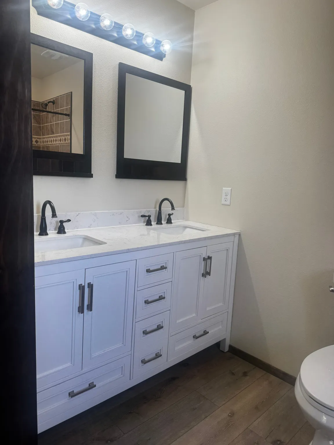 Dual vanity with white cabinetry, integrated sinks, white countertop, and matte black fixtures