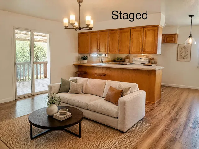 Wood-finish flooring throughout, sliding glass door leading to an outdoor deck, recessed lighting, wood cabinetry, and a built-in kitchen peninsula