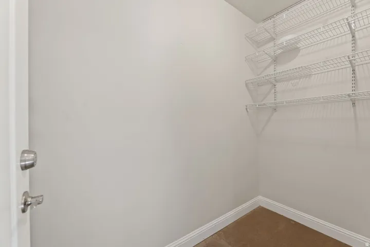 Wall-mounted wire shelving system, carpeted flooring, and neutral wall tones