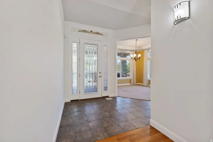 Entryway featuring leaded glass double doors with sidelights, tile flooring, and a decorative transom