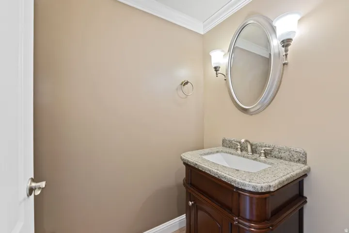 Dark wood-finish vanity with an integrated sink, stone countertop, and brushed nickel fixtures