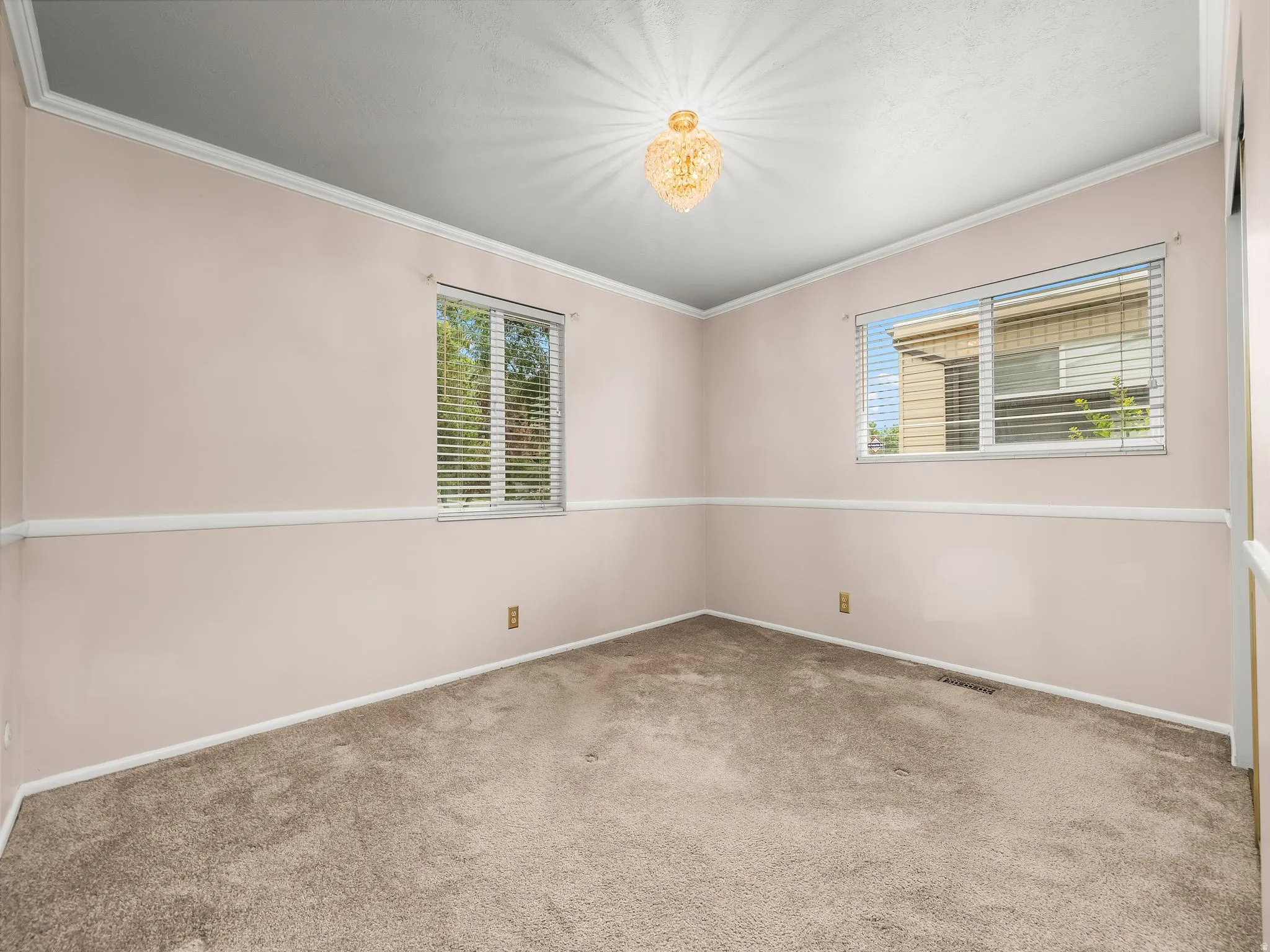 Neutral-toned carpeting with light-colored walls and crown molding