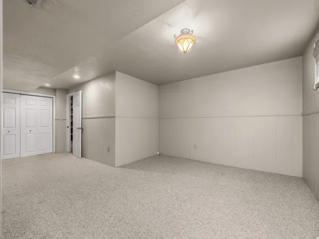 Neutral-toned carpeting, white bi-fold closet doors, recessed ceiling lighting, decorative ceiling fixture, and a white paneled wall accent