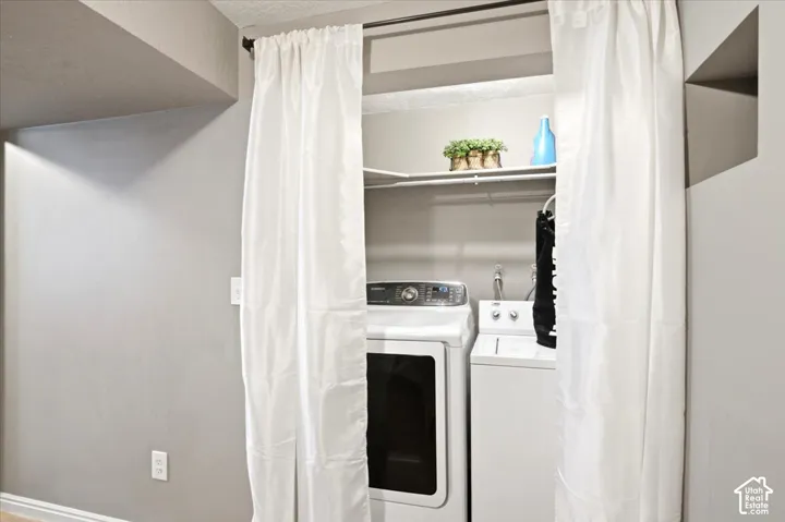 Laundry area featuring a built-in shelf and white curtain enclosure