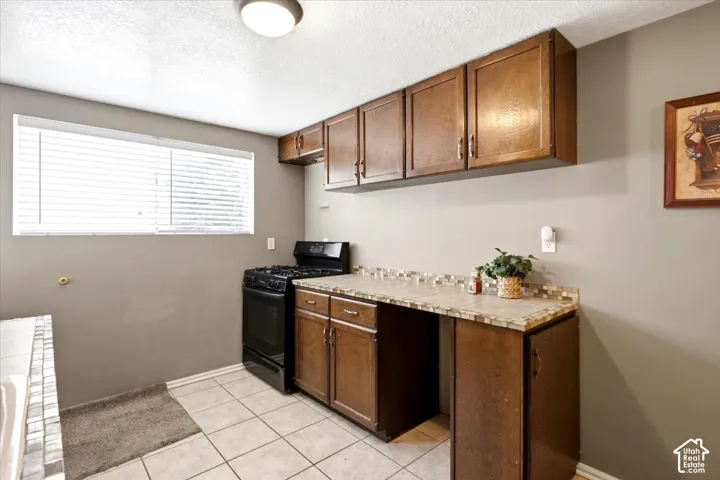 Wood-finish cabinetry paired with a tile countertop and decorative backsplash