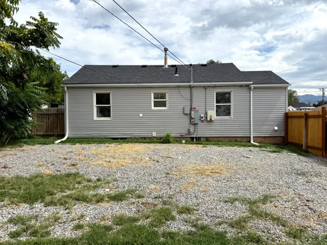 Gray vinyl siding exterior with a dark shingle roof