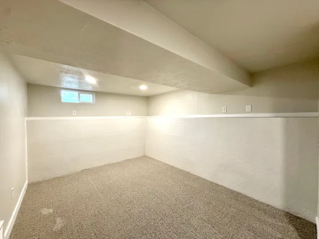 Recessed lighting, wall-to-wall carpeting, and a window for natural light