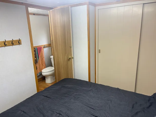 Wood-finish trim, built-in closet with sliding doors, and a wood-finish door