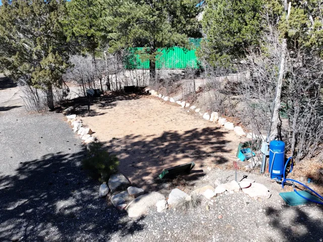 Gravel driveway bordering a defined perimeter with natural stone accents and mature trees