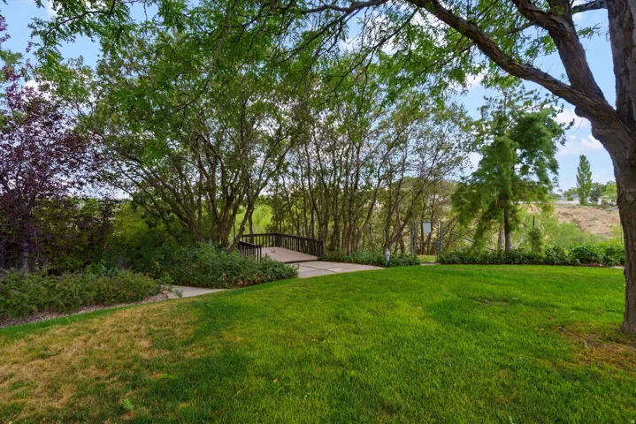 a custom built deck at the corner of the backyard offers a beautiful look-out view of Big Willow Creek.