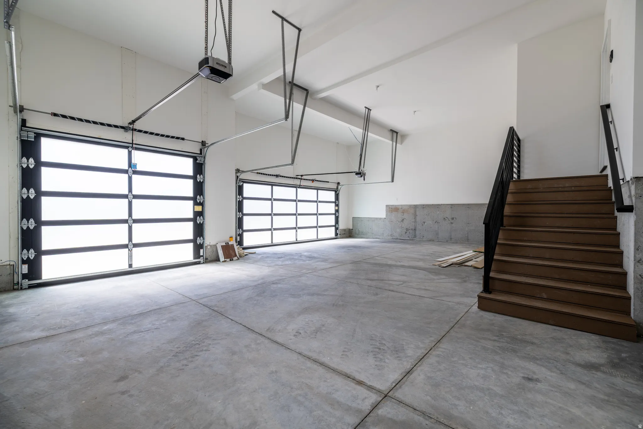 Spacious garage with concrete flooring and multiple overhead doors