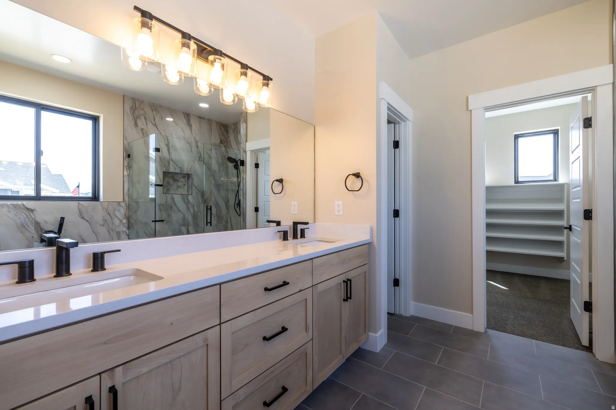 Dual vanity with light wood-finish cabinetry and matte black fixtures