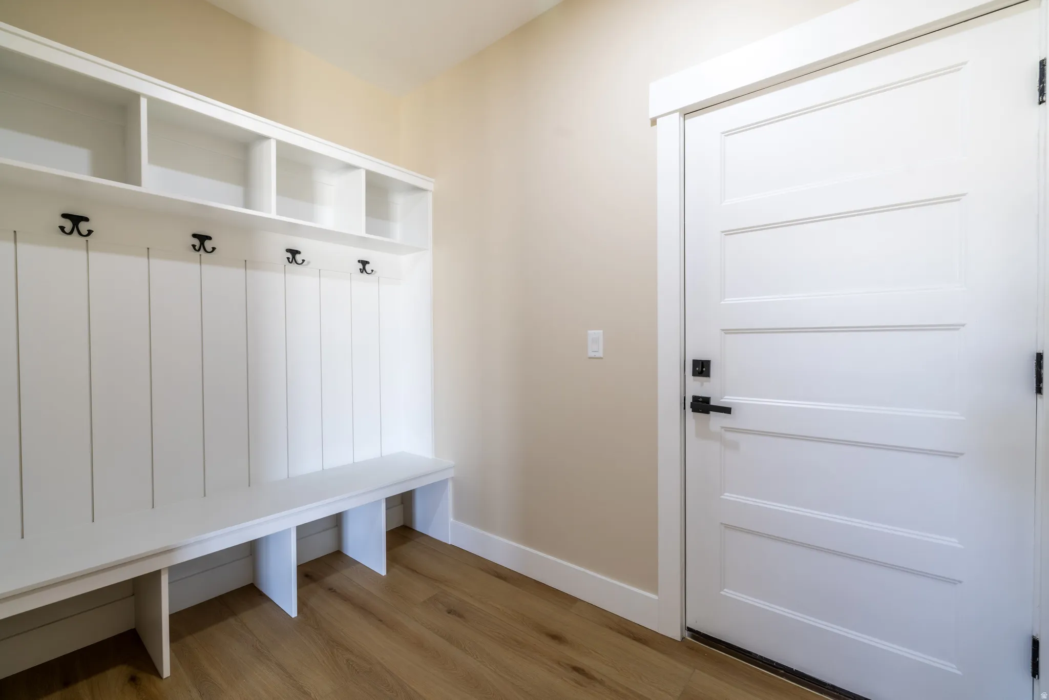 Built-in mudroom bench with cubbies, upper shelving, and coat hooks