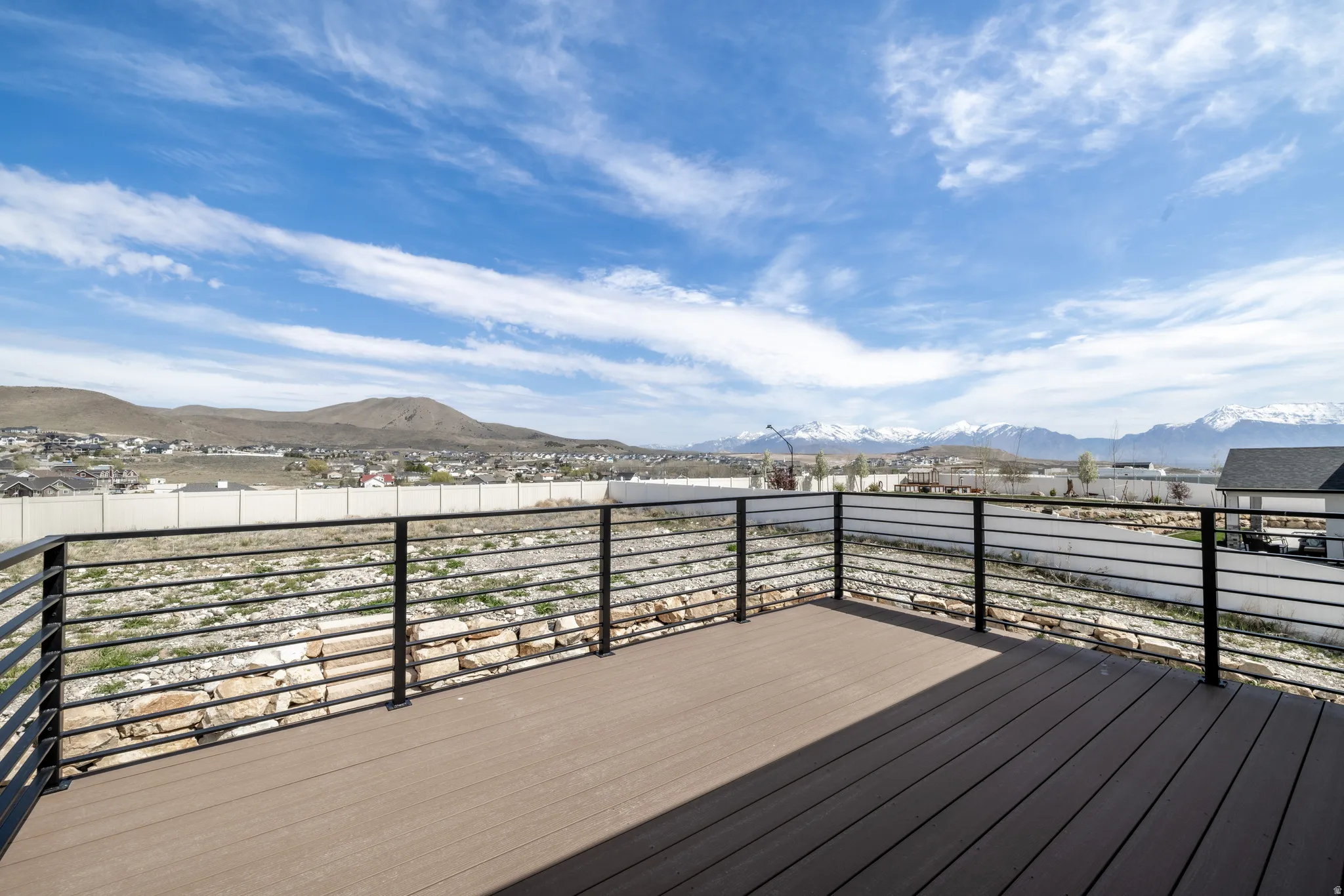 Expansive outdoor deck with composite wood-finish flooring and modern horizontal metal railings