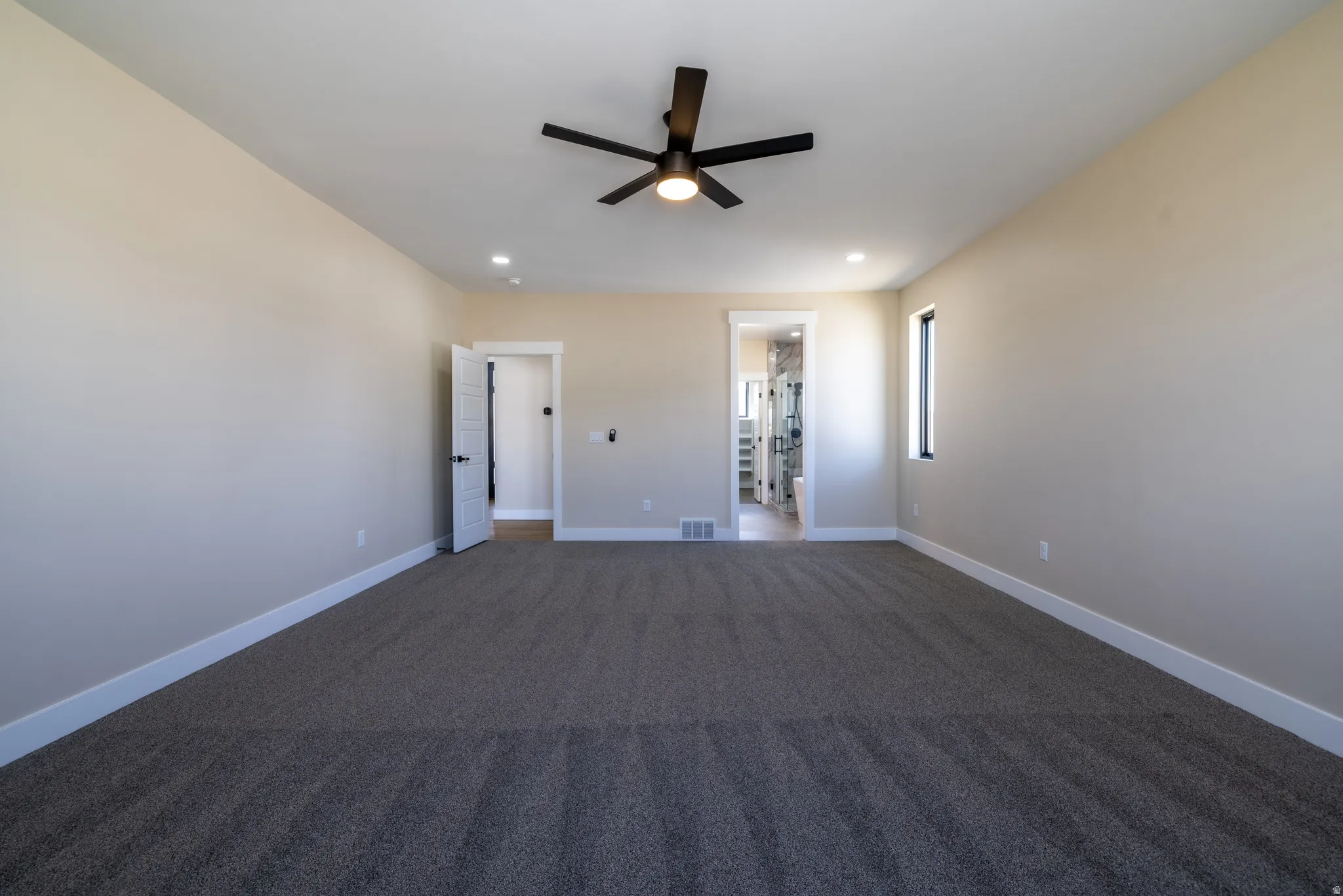 Spacious room with dark gray carpeting, a contemporary ceiling fan, recessed lighting, and a modern window frame