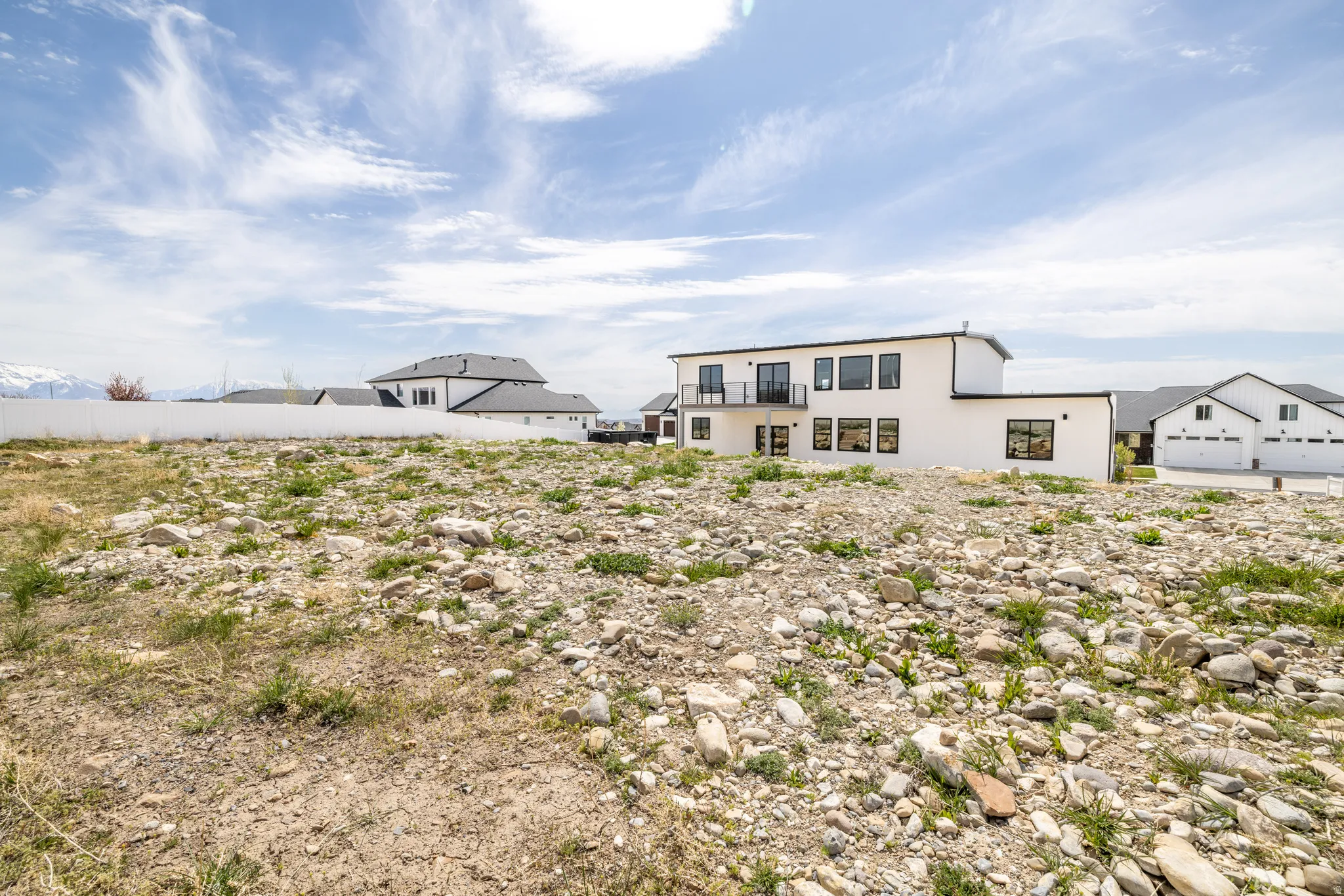 Expansive undeveloped lot featuring varied ground cover and a distant mountain backdrop