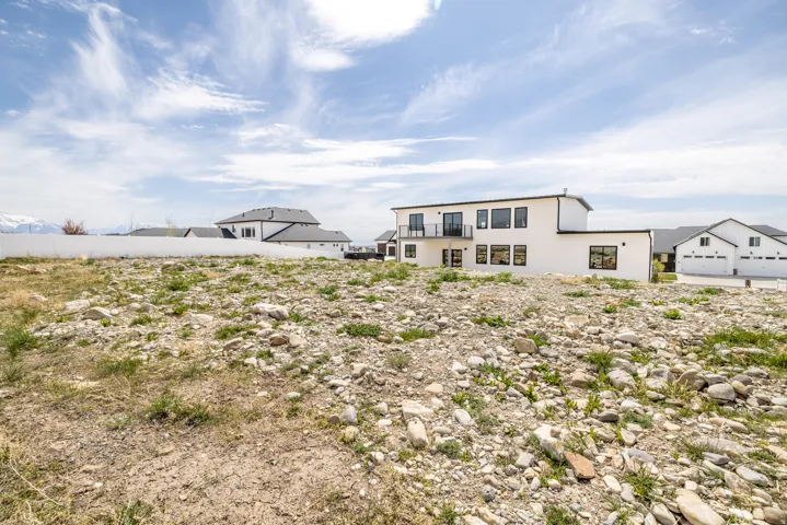 Expansive undeveloped lot featuring varied ground cover and a distant mountain backdrop