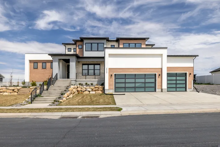 Contemporary exterior with mixed material facade, multiple large windows, and a multi-level roofline