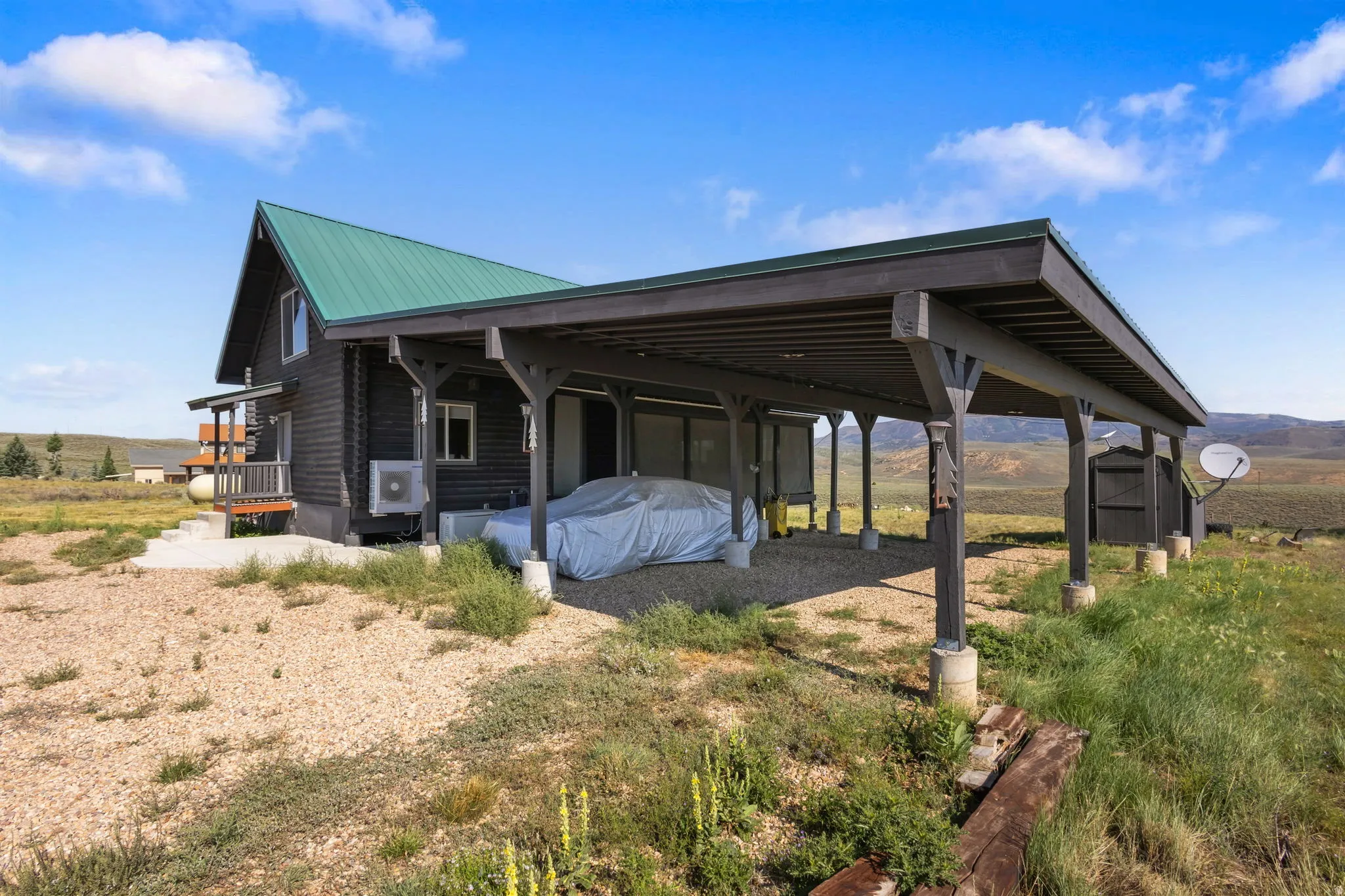 Log-style siding exterior with a green metal roof