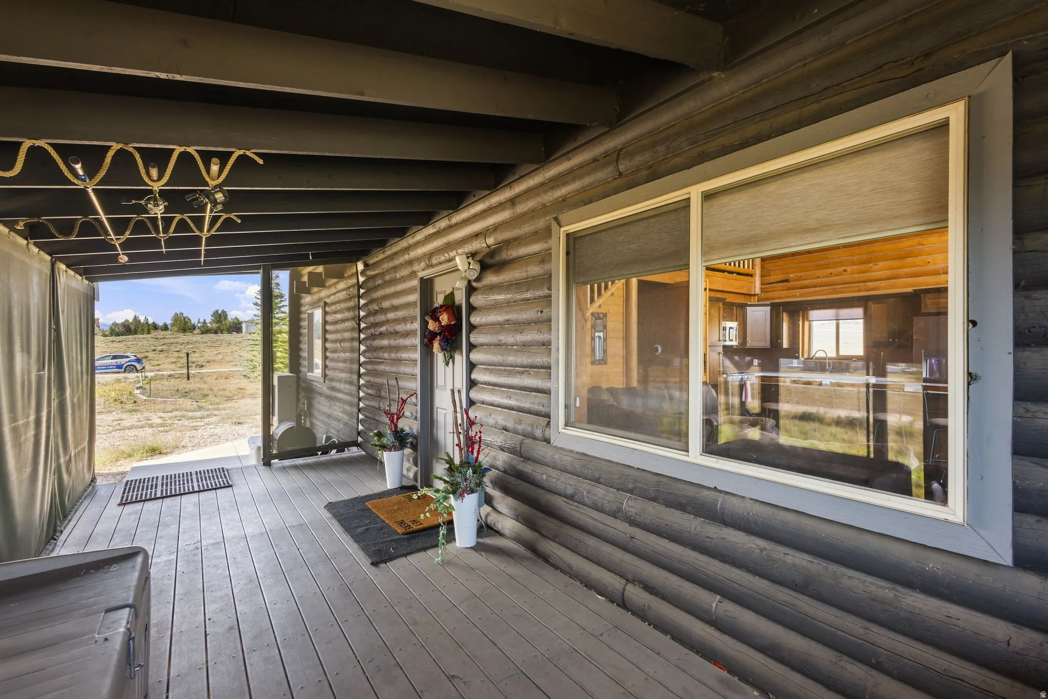 Log exterior with a covered porch featuring wood-finish decking and a single-pane window