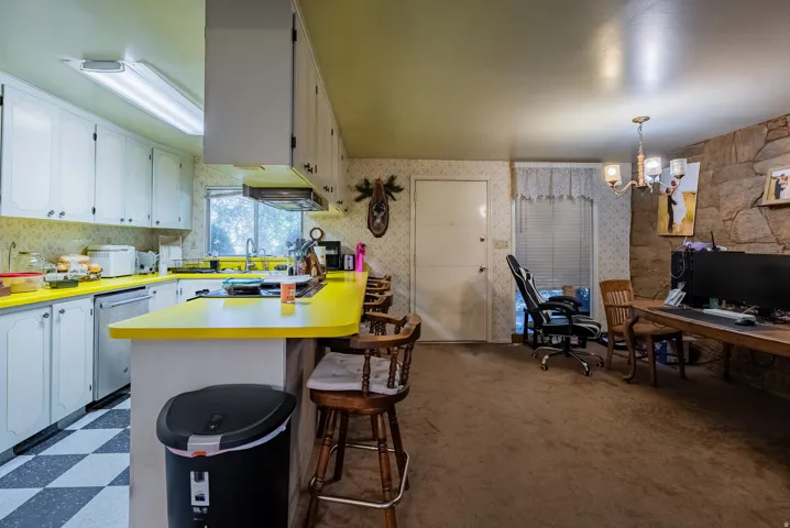 Kitchen with white cabinetry, bright yellow countertops, and a checkered floor