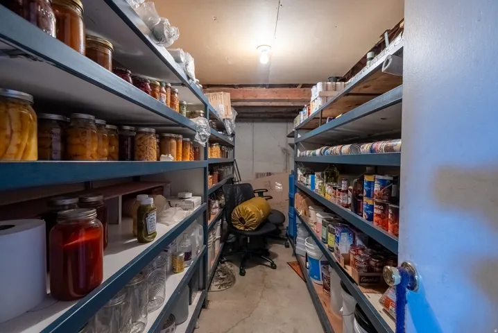 Concrete flooring, exposed ceiling joists, and extensive built-in shelving units