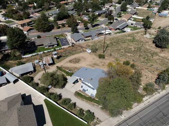 Expansive lot featuring a main residence with a gray roof and multiple outbuildings